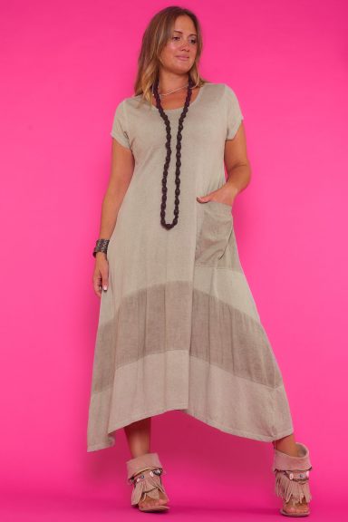 Un vestido largo de manga corta que tiene un bolsillo frontal y es elástico. Tiene un corte asimétrico, con sus laterales más largos.