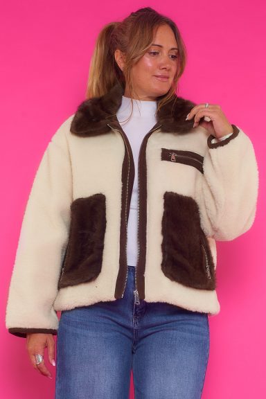 Un abrigo grueso que tiene dos bolsillos frontales reales que se pueden cerrar con una cremallera y uno decorativo en la parte superior.