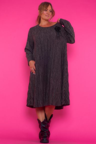 Un vestido corto elástico de manga larga que se caracteriza por ser estilo baggy, por estar completamente estampado y por ser plisado.