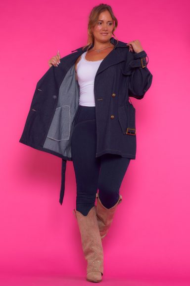 Una chaqueta vaquera elástica que tiene bolsillos y se cierra por medio de botones. Tiene un gran volante en la parte trasera y un cinturón.