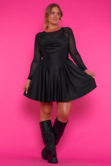 Vestido corto elástico de tirantes regulables. Tiene un drapeado y unas cintas para hacer un nudo. También tiene strass en toda la prenda.