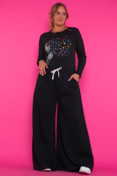 Un pantalón elástico chándal con pata de elefante, goma elástica en la cintura con cordones, bolsillos y tejido de toalla en su interior.