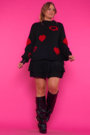 Un jersey elástico de punto de estilo holgado que se caracteriza por tener un diseño de corazones en su tejido que estiliza la prenda.