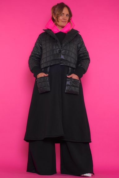 Un abrigo largo elástico que tiene cierre por medio de botones que se caracteriza por tener bolsillos colgantes con cremallera.