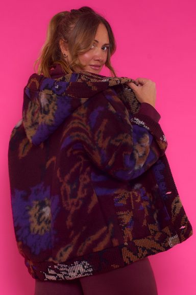 Una chaqueta completamente estampada que tiene dos bolsillos frontales, capucha y un cierre por medio de botones.