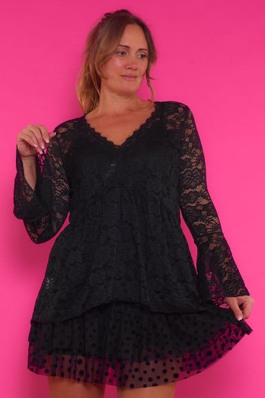 Una blusa de encaje con diseño original que tiene escote en pico, una goma elástica en la cintura y unas mangas acampanadas.