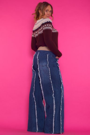 Un pantalón vaquero elástico de pierna ancha que tiene trabillas y bolsillos. Se cierra por medio de botón y cremallera.