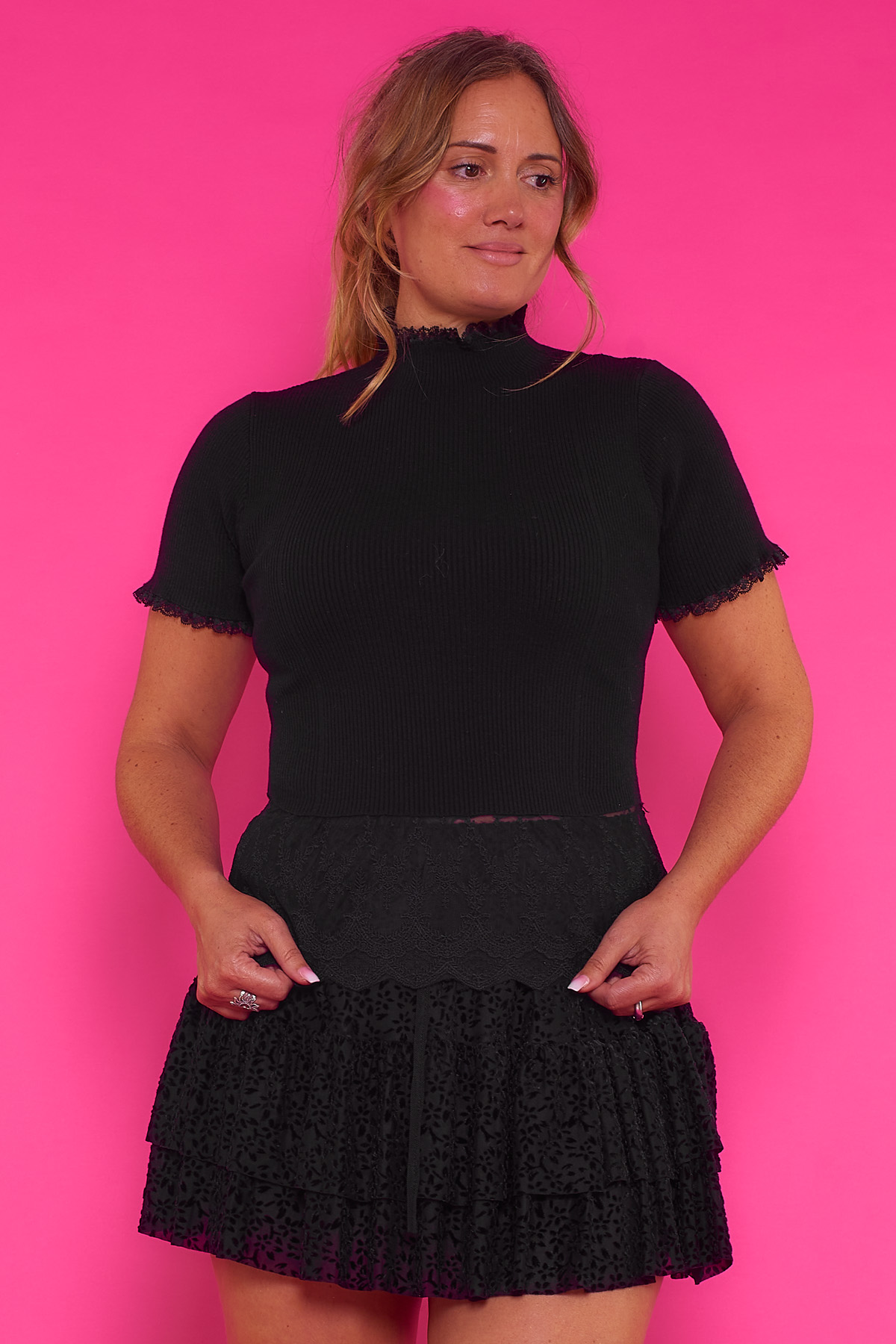 Blusa Con Encaje La Cruz Una blusa elástica de cuello semi alto y manga corta que se caracteriza por tener un encaje original en todos sus bordes.