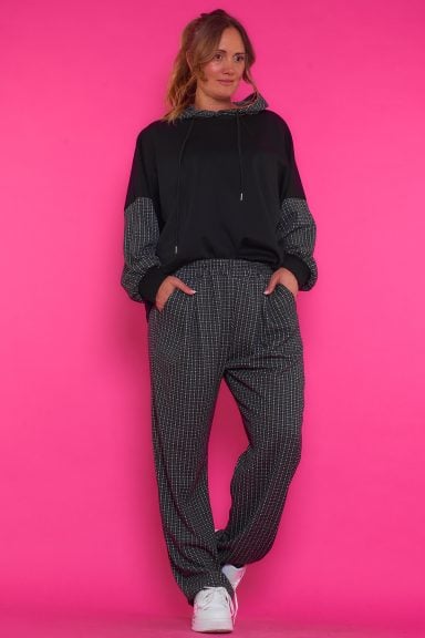 Un conjunto chándal compuesto por una sudadera y un pantalón. Ambas prendas son elásticas y tienen en su tejido un hilo metálico