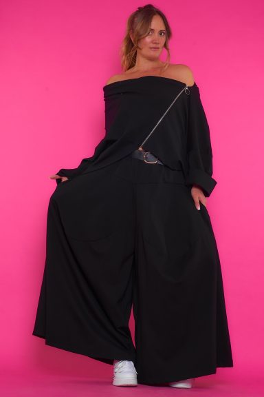 Una chaqueta elástica que tiene un drapeado en el cuello y mangas murciélago. Tiene corte asimétrico y una cremallera cruzada.