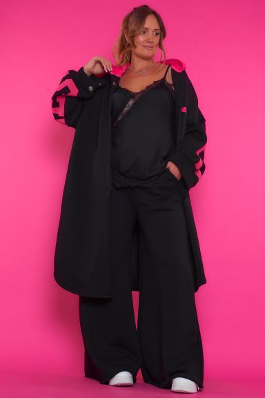 Un abrigo largo elástico que tiene bolsillos laterales, capucha y cierre por medio de botones. Tiene forro polar en su interior.