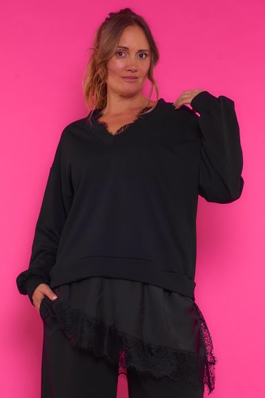 Una sudadera elástica que tiene escote en pico y que se caracteriza por tener un volante en su parte inferior con diseño de encaje.