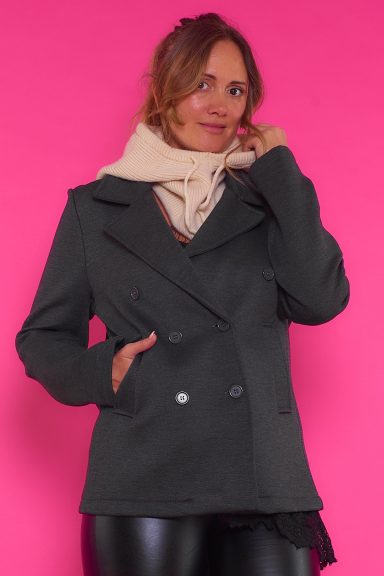 Una chaqueta elástica de estilo elegante y sofisticado que tiene bolsillos frontales y que se puede cerrar por medio de botones.