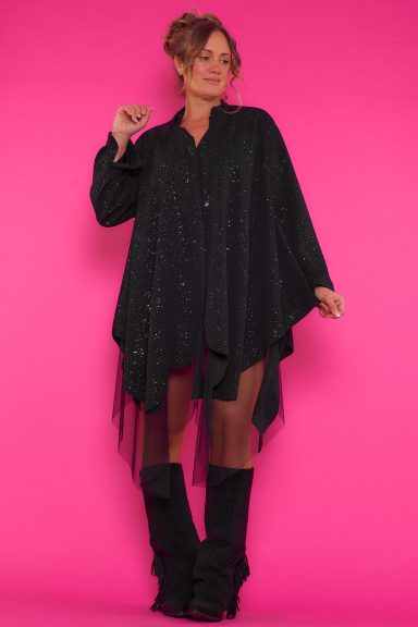 Un vestido elástico de corte asimétrico que tiene cierre por medio de botones y un volante de tul en su parte inferior.