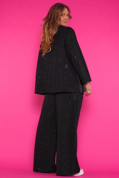 Un pantalón elástico que tiene un brillo disimulado en su tejido. Tiene bolsillos laterales y una goma elástica en la cintura con cordones.