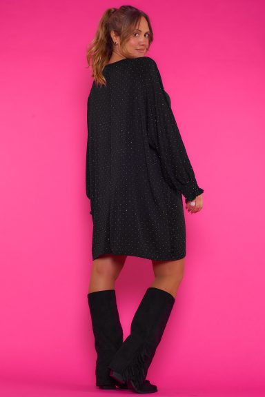 Un vestido corto elástico que se caracteriza por tener strass esparcidos en toda la prenda y nido de abeja en los puños de las mangas.