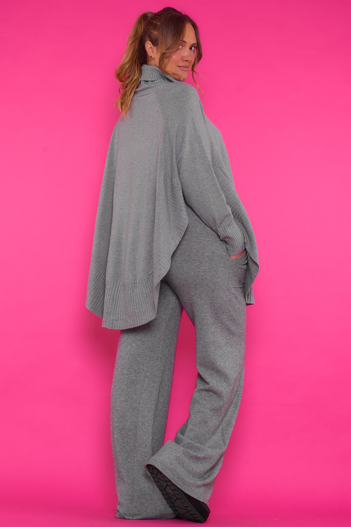 Jersey Poncho Asimétrico Maceo Un jersey elástico que tiene cuello de tortuga y bolsillos frontales que se caracteriza por tener un corte estilo poncho.