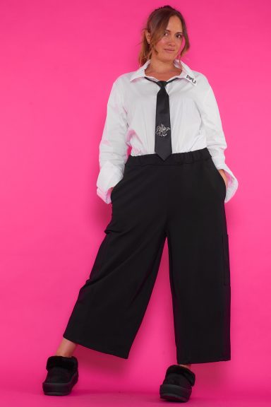 Un pantalón elástico de pierna ancha que tiene bolsillos laterales superiores e inferiores. La prenda tiene una goma elástica en la cintura.