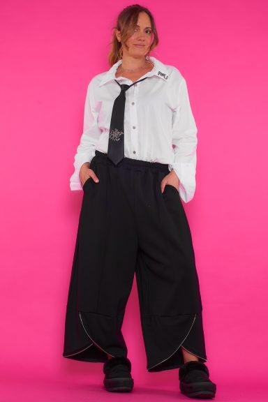 Un pantalón elástico de pierna ancha que tiene bolsillos laterales y cremalleras decorativas en su parte inferior.