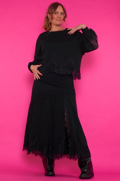 Una sudadera elástica de cuello redondo que se caracteriza por tener decoración de encaje en su parte inferior y en sus mangas.