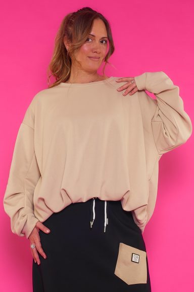 Una sudadera elástico de cuello redondo que se caracteriza por tener un corte globo que estiliza la prenda por completo.