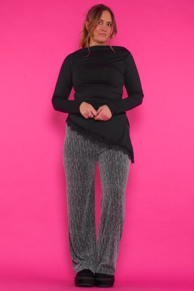 Un pantalón que se caracteriza por tener un tejido metálico y strass esparcidos en toda la prenda, tiene un brillo disimulado la prenda.