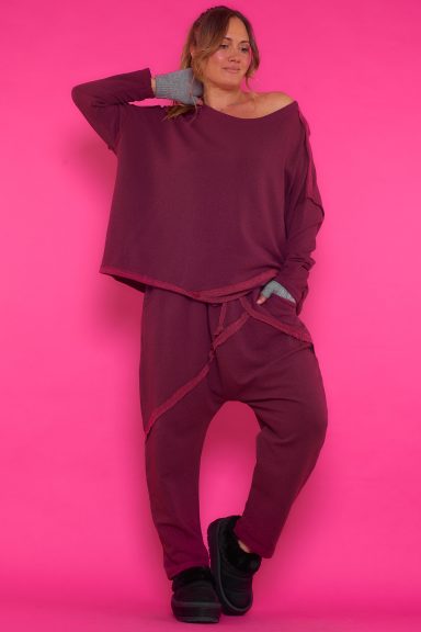 Un conjunto elástico de estilo baggy que está compuesto por una sudadera y un pantalón que tienen costuras expuestas de decoración.