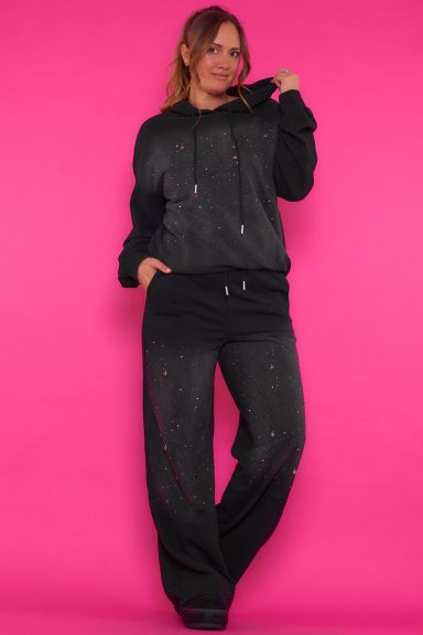 Un conjunto elástico que tiene strass esparcidos en su tejido que está compuesto por una sudadera y un pantalón.