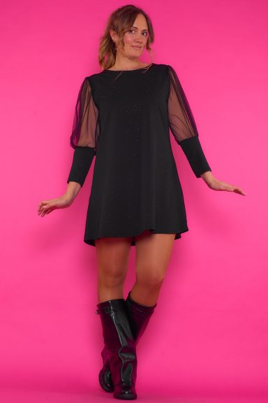 Un vestido corto elástico que se caracteriza por tener strass negros esparcidos en toda la prenda y por tener sus mangas de tul.