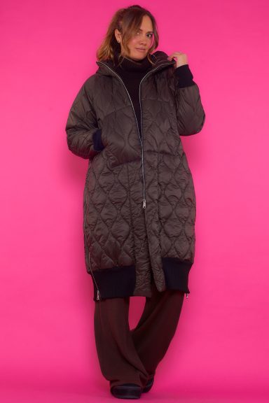 Un abrigo largo que tiene capucha y bolsillos frontales que se caracteriza por tener aperturas laterales que se pueden regular.