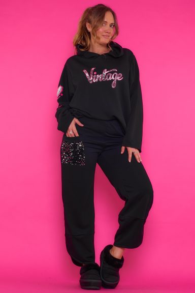 Un pantalón que tiene una goma elástica en la cintura y un par de bolsillos frontales con lentejuelas aterciopeladas de decoración.