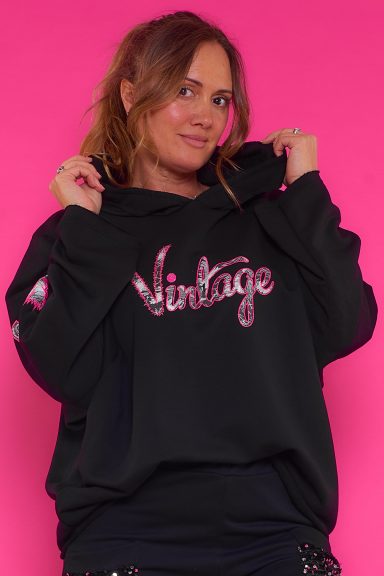 Una sudadera elástica asimétrica que tiene capucha y un estampado con textura en su parte frontal. Su tejido interior es estilo toalla.