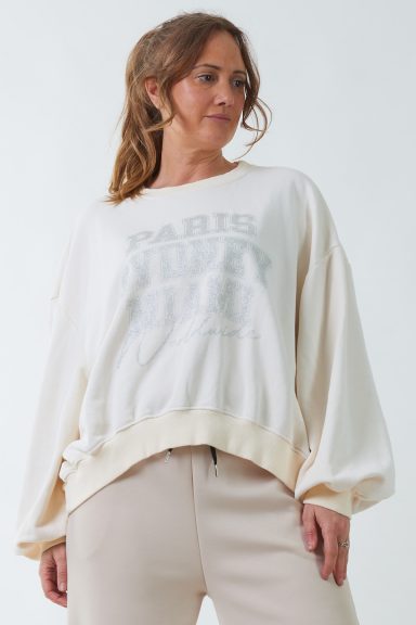 Una sudadera elástica de manga larga y cuello redondo que tiene un estampado en la parte frontal con brillo.