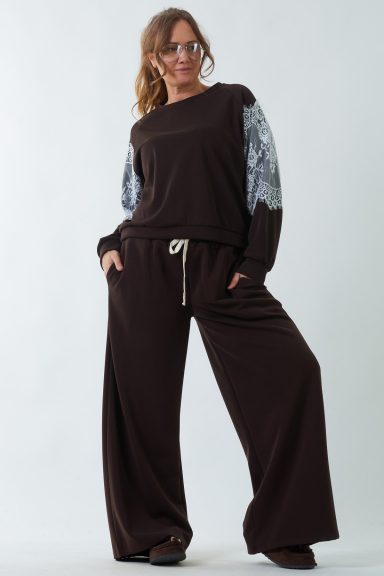 Un pantalón elástico de pierna ancha que tiene dos bolsillos laterales y una goma elástica en la cintura con cordones.