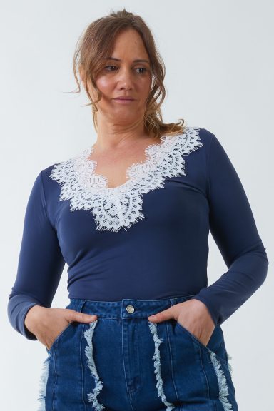 Una blusa elástica de manga larga que tiene un escote en pico que se caracteriza por tener un diseño original en la parte frontal.