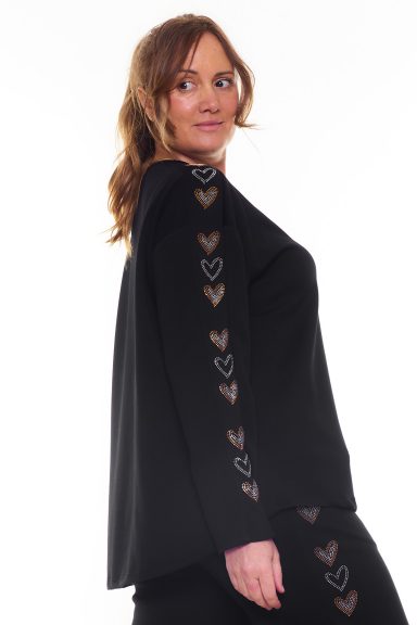 Una sudadera elástica de tejido extremadamente suave, se caracteriza por tener un estampado en las mangas hecho y formado con strass.