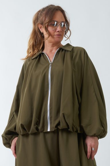 Una chaqueta elástica de corte globo que tiene cierre por medio de cremallera y una capucha que estiliza la pieza por completo.