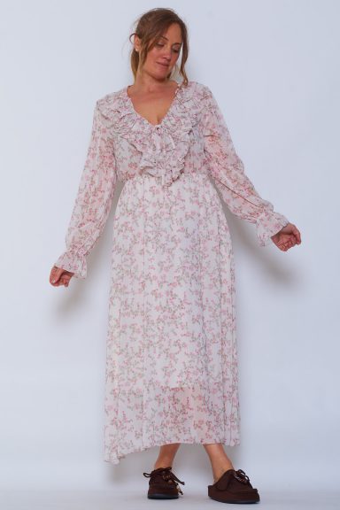 Un vestido largo completamente estampado que tiene escote en pico con volantes, una goma elástica en la cintura y un forro interior elástico.