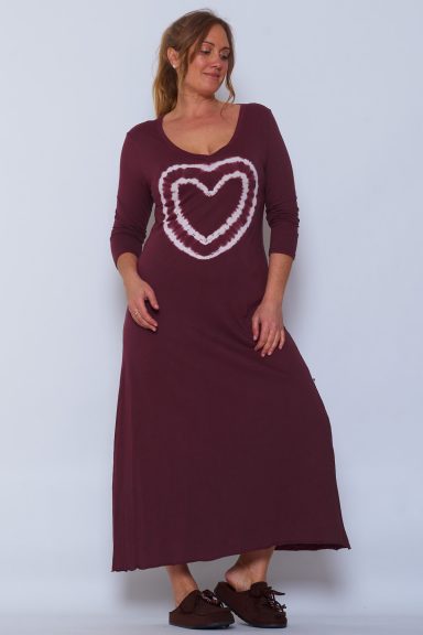 Un vestido largo que tiene escote en pico, un estampado de un corazón en la parte frontal y manga larga. Su tejido es ligero y suave.