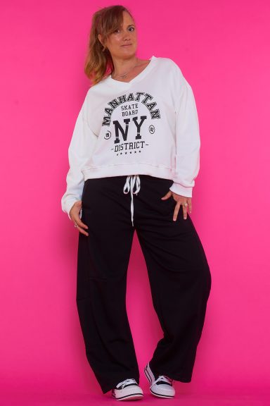 Un pantalón elástico que tiene bolsillos y una goma elástica en la cintura con cordones que tienen hilo metálico de decoración.