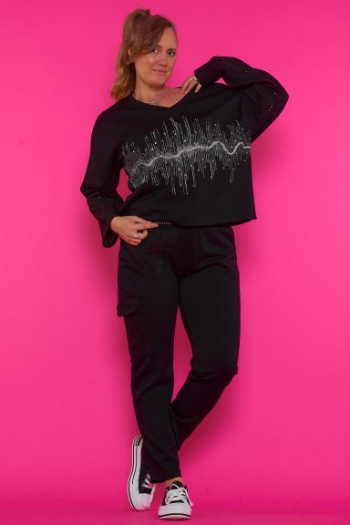 Un pantalón elástico de corte pitillo que tiene bolsillos, goma elástica en la cintura con cordones que tienen hilo metálico de decoración.