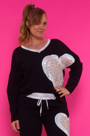 Una sudadera elástica que tiene escote en pico y un estampado que tiene lentejuelas de decoración y parte con tejido brillante.