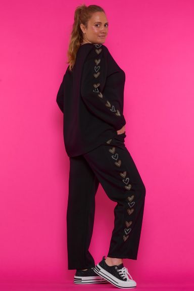 Un pantalón elástico que tiene bolsillos, un estampado formado con strass y una goma elástica con cordones.