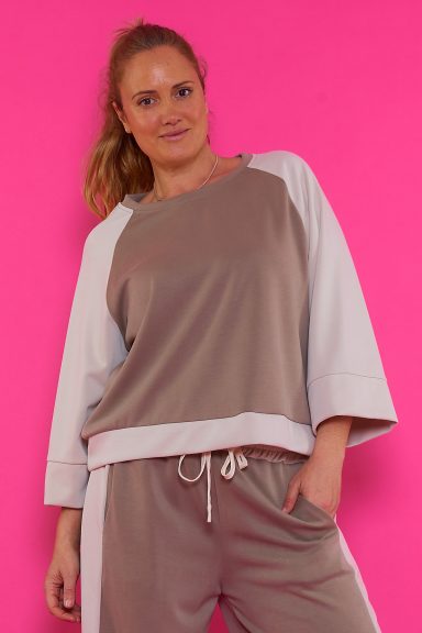 Una sudadera elástica bicolor de manga ancha que tiene un tejido extremadamente suave y agradable al tacto.