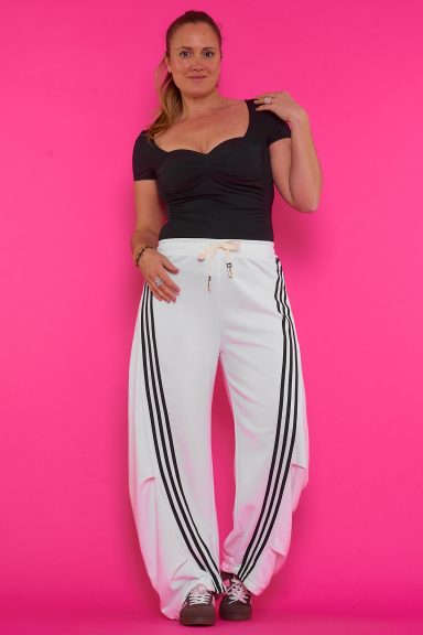 Un pantalón elástico que tiene rayas decorativas, bolsillos traseros, cordones y una goma elástica en la cintura.
