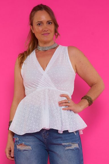Descubre la blusa Oru, una prenda boho-chic de algodón con bordado y escote cruzado. Su diseño peplum realza tu silueta. ¡Ideal para un look veraniego y estilizado!