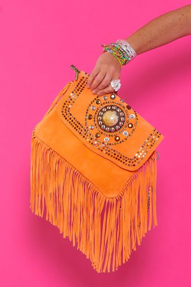 Eleva tu estilo boho con el bolso Jaune Naranja. Flecos, tachuelas y un diseño exclusivo que aporta carácter a cualquier look. ¡Hazte con tu complemento estrella!