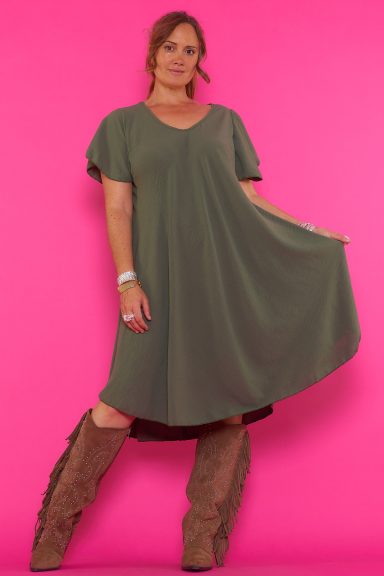 Un vestido corto elástico que tiene escote en pico y una caída muy fluida. La prenda tiene manga corta y un tejido suave y ligero.